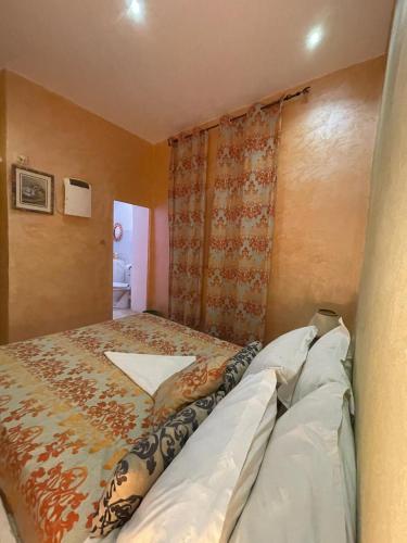 a small bedroom with a bed with a curtain at Hôtel familiale les grotte in Aït Ben Haddou
