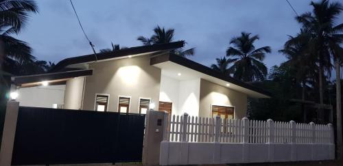 KadawataにあるArchie Homesの白い柵の白い家