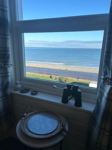 ein Badezimmerfenster mit einem WC und Meerblick in der Unterkunft Glan Y Mor Hotel (Adult Only) in Llandudno