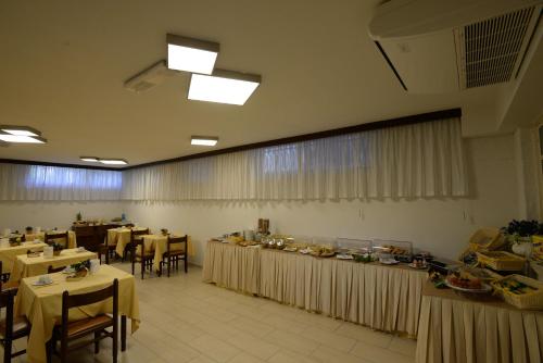 a dining room with tables and chairs and tablesktop at Hotel Giulio Cesare in Cinquale