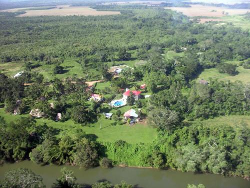 an aerial view of a house on the banks of a river at Banana Bank Lodge & Jungle Horseback Adventures in Belmopan