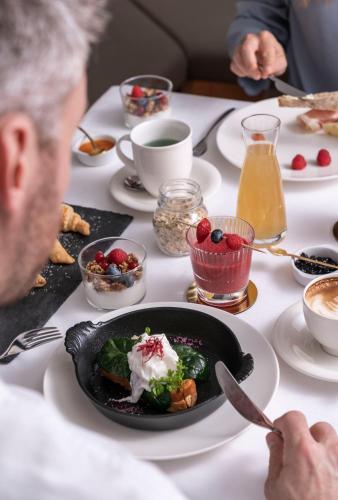 a man sitting at a table with a plate of food at Zum Hirschen Boutique Hotel Val di Non in Unsere Liebe Frau im Walde