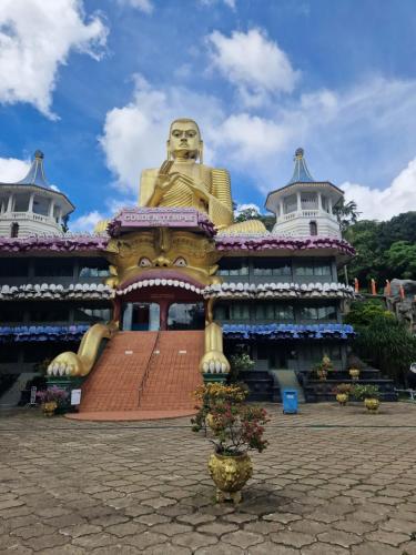 a large building with a statue in front of it at Nature Paradise Guesthouse in Waikkal
