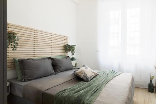 a bed in a bedroom with a large window at Luni 4 - Design trilo suite -M3- 8 min dal Duomo in Milan