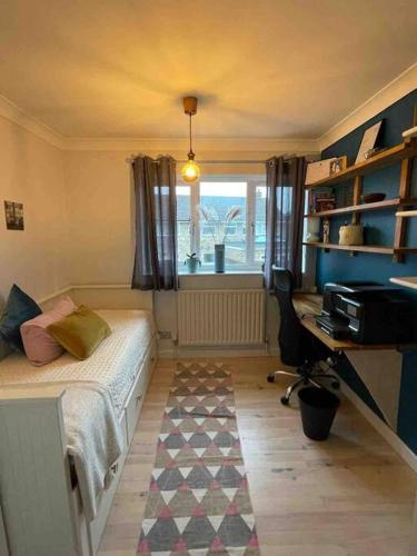 a bedroom with a bed and a desk and a window at Milan Casa in Winnersh