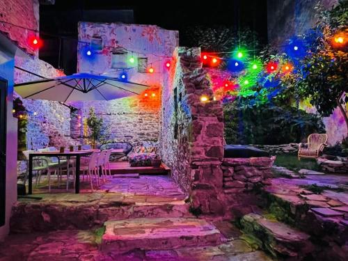 un patio con una mesa con sombrilla y luces en Forget Me Not, en Kavala