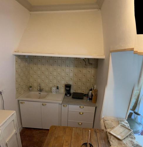 a kitchen with a sink and a wooden table at Le Château de Leugny in Oiron