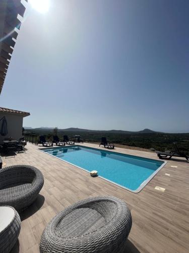 - une piscine avec 2 chaises dans l'établissement Villa avec piscine 3 étoiles proche plages, à Monacia-dʼAullène