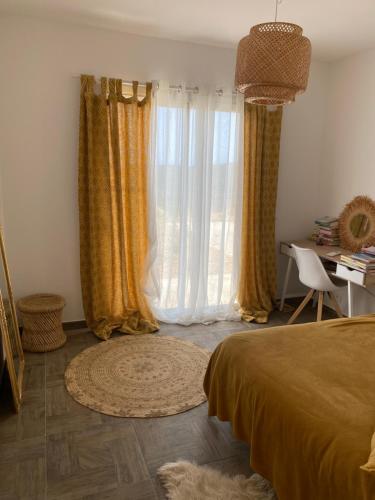 - une chambre avec un lit, un bureau et des rideaux dans l'établissement Villa avec piscine 3 étoiles proche plages, à Monacia-dʼAullène