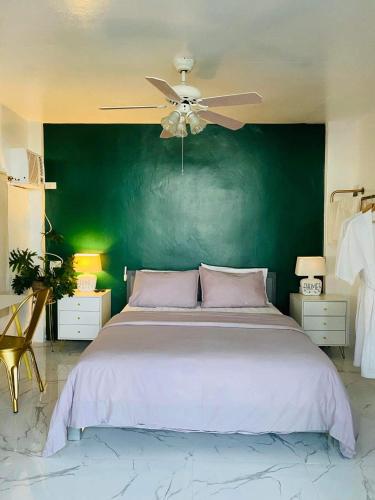 a bedroom with a large bed with a green wall at Bintana sa Paraiso Binunsaran in Mambajao