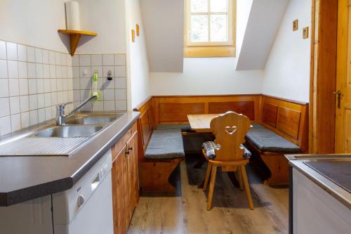 a kitchen with a sink and a wooden table at Die Traunmühle in Bad Aussee