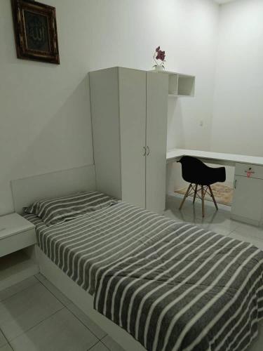 a bedroom with a bed with a desk and a chair at Soho Sri iskandar in Kampong Bota Road