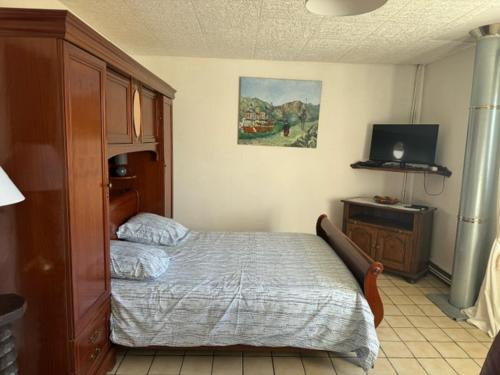 a bedroom with a bed and a television in it at Appartement OMAHA BEACH in Saint-Laurent-sur-Mer