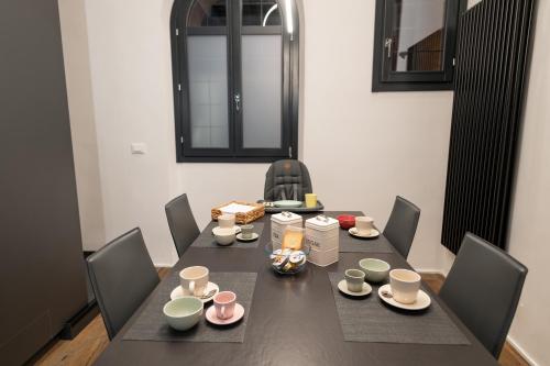 a dining room table with chairs and a table with cups at Luxury House in Bologna Marchesana 100 mq in Bologna