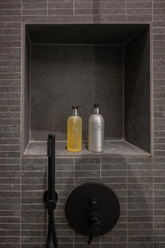 two bottles of soap sitting on a shelf in a bathroom at Luxury House in Bologna Marchesana 100 mq in Bologna