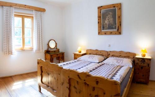 Schlafzimmer mit einem Holzbett und einem Spiegel in der Unterkunft Die Traunmühle in Bad Aussee
