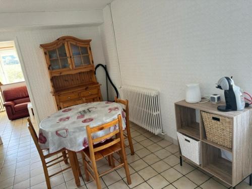 - une cuisine avec une table, une table et des chaises dans l'établissement Appartement OMAHA BEACH, à Saint-Laurent-sur-Mer