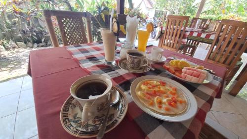 un tavolo con una tazza di caffè e un piatto di cibo di The Bukit Artha a Karangasem