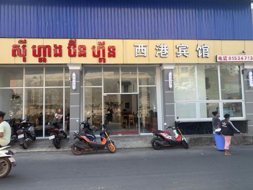 een groep motorfietsen geparkeerd voor een winkel bij 西港宾馆 in Sihanoukville