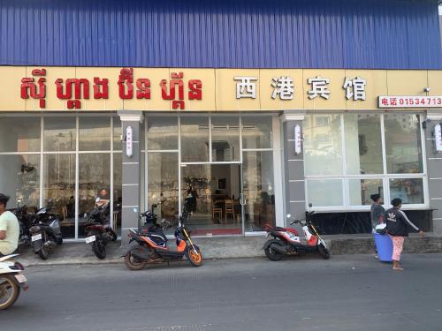 un grupo de motocicletas estacionadas frente a una tienda en 老骆西港宾馆, en Sihanoukville