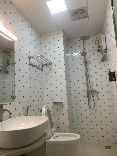 La salle de bains est pourvue d'un lavabo, de toilettes et d'une douche. dans l'établissement 西港宾馆, à Sihanoukville