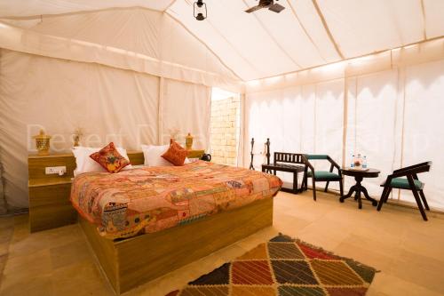 a bedroom with a bed and a table in a tent at Desert Dream Royal Camp with Pool in Jaisalmer