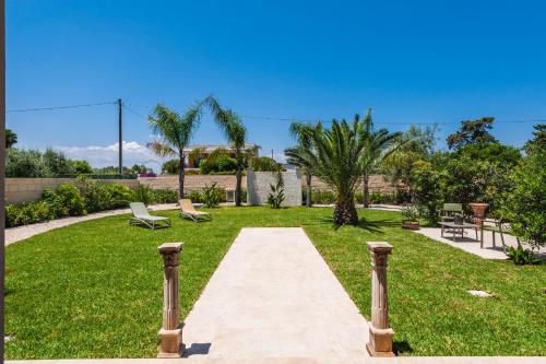 a walkway through a park with chairs and palm trees at 5E Villa Charme-Sea and Ortigia view-Whirlpool roof Terrace in Siracusa