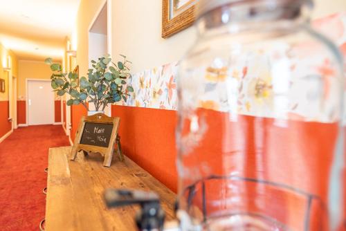 a bottle on a wooden table with a sign on it at Strandhotel Möwe in Bansin