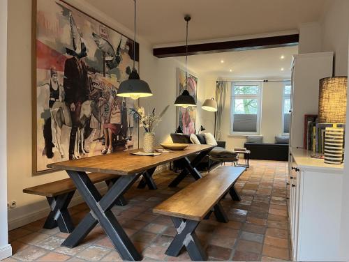 a dining room with a table and benches at Simmerdeis an der Gracht: Charmantes Grachtenhaus direkt mit Blick auf Kanal und Treene in Friedrichstadt