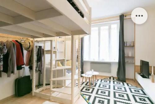um quarto com uma cama alta e um tapete em Belle chambre dans le quartier latin em Paris
