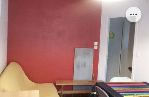 um quarto com uma parede vermelha e uma mesa e cadeiras em Belle chambre dans le quartier latin em Paris