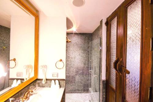 a bathroom with a sink and a shower and a mirror at Buri Sriping Riverside Resort & Spa in Chiang Mai