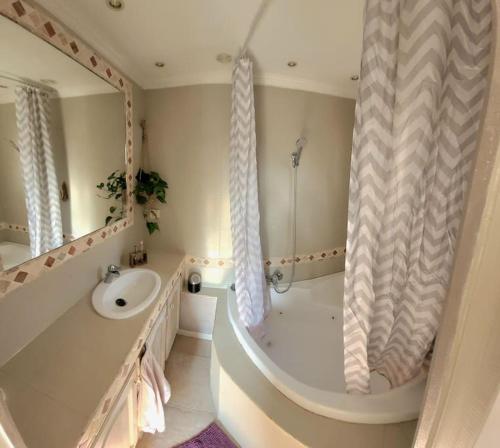 une salle de bain avec une baignoire, un lavabo et une douche dans l'établissement Vacances cosy au soleil, à Fréjus