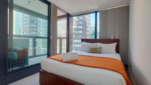een bed in een kamer met een groot raam bij Sky Stars Park Apartment in Auckland