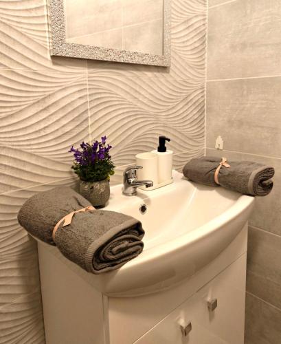 a bathroom with a sink with towels on it at DáMa Apartments in Eger