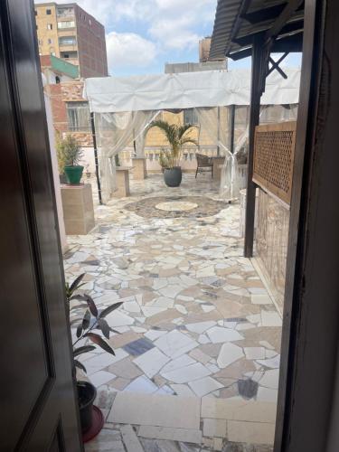 una puerta abierta con un patio de piedra con una tienda de campaña en Badr pyramids inn en El Cairo