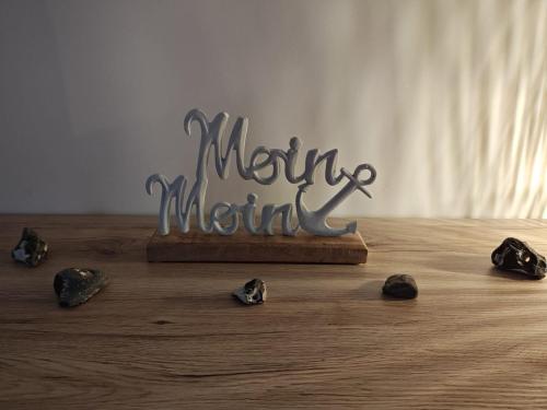 una señal de metal sobre una mesa de madera con rocas en Ferienwohnung Boddenliebe, en Polchow