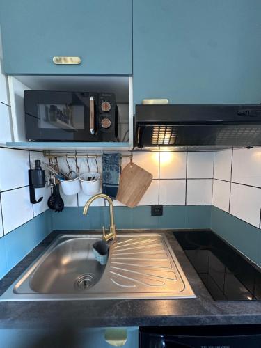 une cuisine avec un évier et un micro-ondes dans l'établissement Joli Studio le clos d'Aix avec grande terrasse piscine et parking gratuit, à Aix-en-Provence