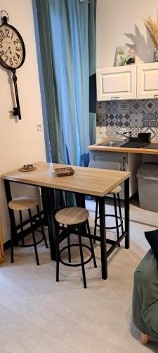 une table et des tabourets dans une cuisine avec une horloge dans l'établissement Appartement 1er Marseille Saint-Charles, à Marseille