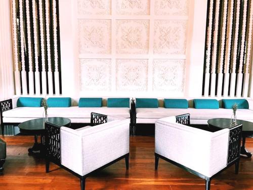 a room with chairs and tables and a couch at Buri Sriping Riverside Resort & Spa in Chiang Mai