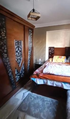a bedroom with a bed and a wooden wall at الاسكندرية المندرة بحرى in Alexandria