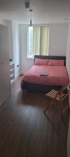 a bedroom with a bed and a table and a window at Cosy Home in London