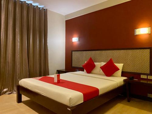 ein Schlafzimmer mit einem großen Bett mit roten Kissen in der Unterkunft Asiatel Airport Hotel in Manila