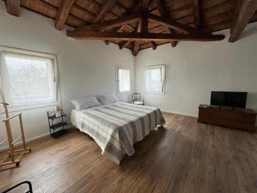 1 dormitorio con 1 cama y TV de pantalla plana en Casa Toè Quinto, en Quinto di Treviso
