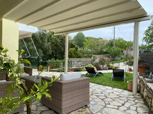 a pavilion with chairs and a swing in a garden at 350m Above Sea in Vasiliki