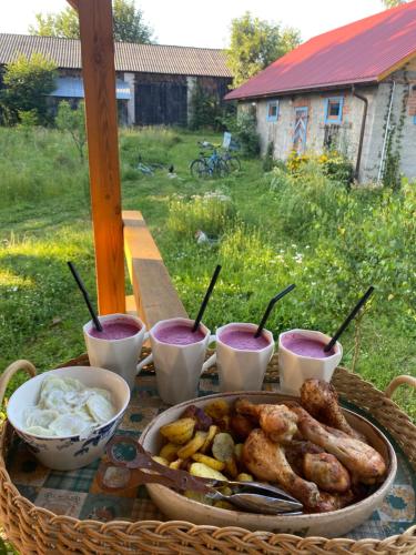 a table with a plate of food and some drinks at Klocówka Roztocze in Majdan Wielki