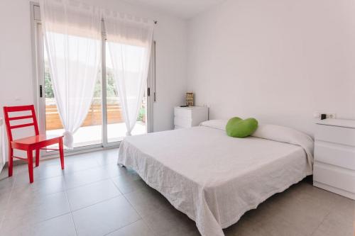 ein Schlafzimmer mit einem Bett mit einem grünen Kissen darauf in der Unterkunft MODERN VILLA IN COSTA BRAVA in Llagostera