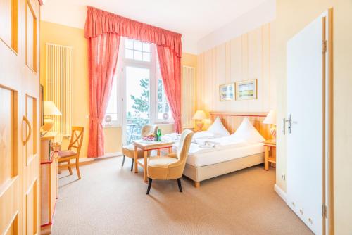 a hotel room with a bed and a table at Strandhotel Möwe in Bansin