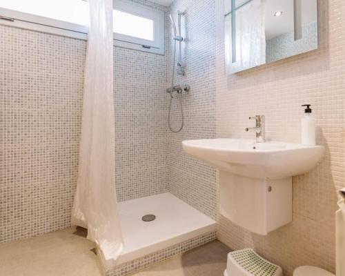 ein weißes Bad mit einem Waschbecken und einer Dusche in der Unterkunft MODERN VILLA IN COSTA BRAVA in Llagostera
