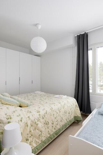 a white bedroom with a bed and a window at New 2BR design home with sauna Espoo Park in Espoo